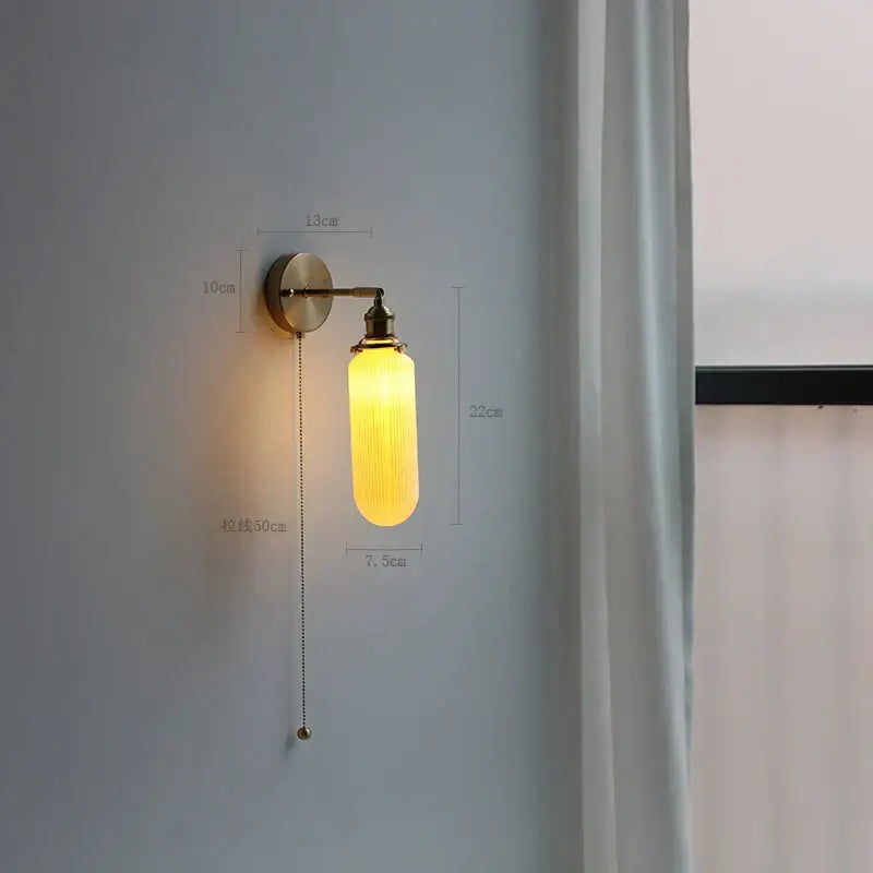 Modern brass wall lamp with warm yellow ribbed glass shade and decorbites copper arm wall sconce with pull chain