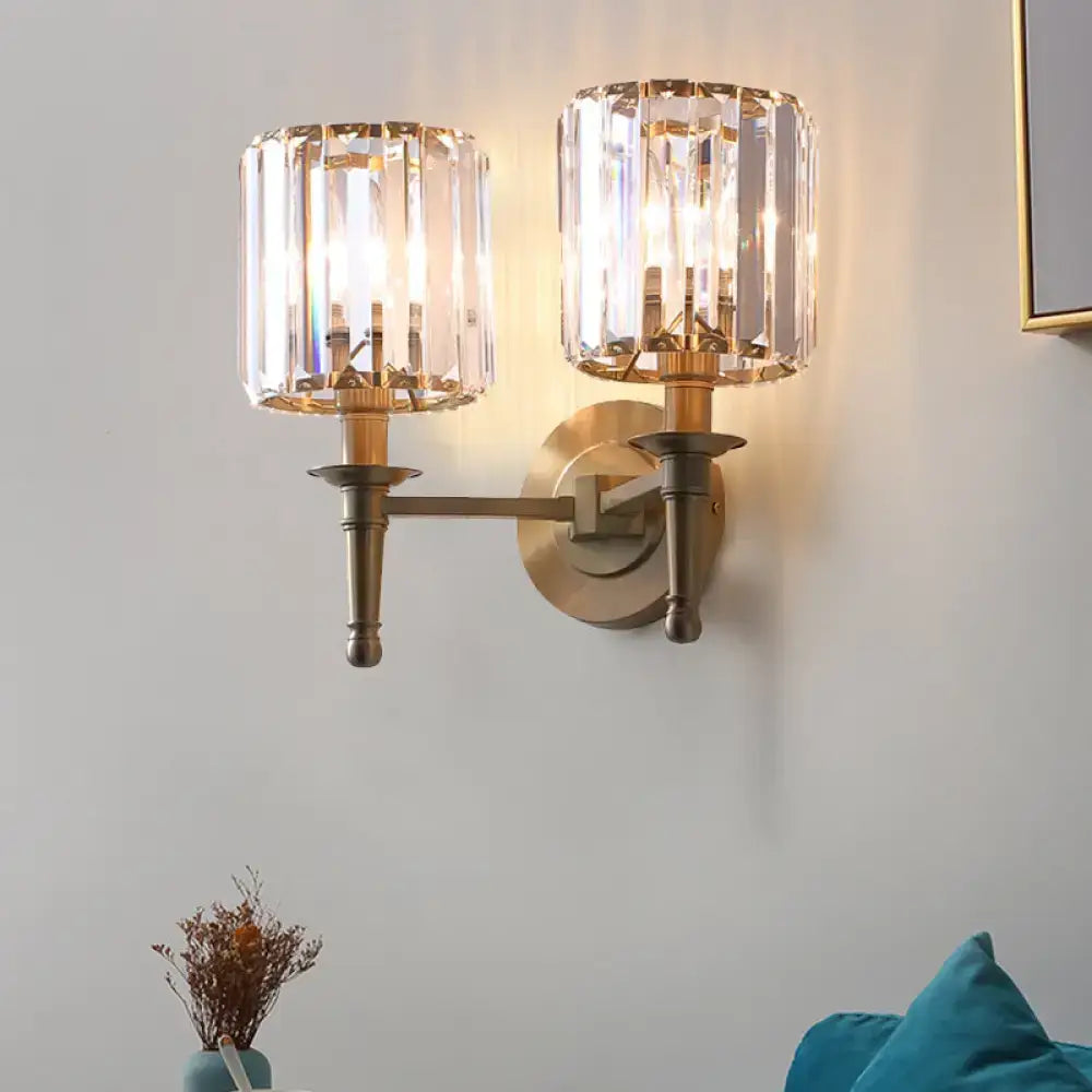 Modern brass wall light sconce featuring two crystal shade encased fixtures ideal for bedroom lighting