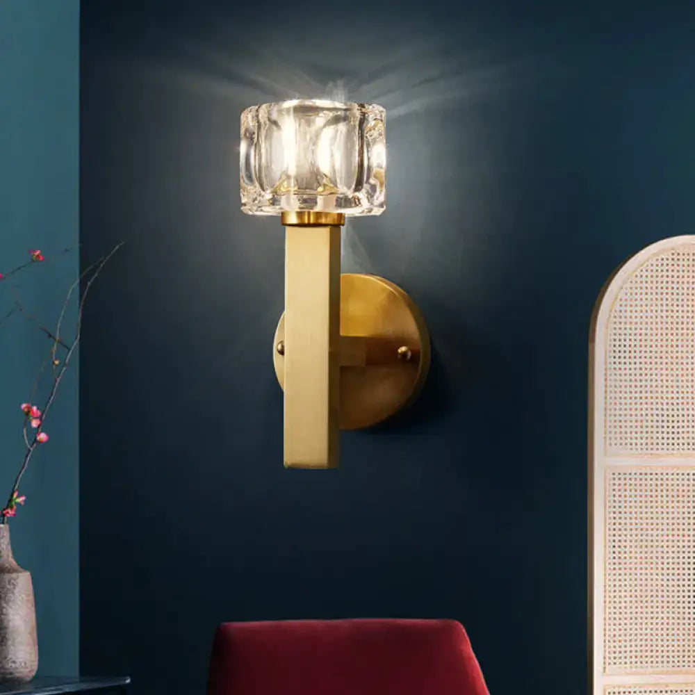 Modern brass wall light with polished finish and clear crystal block faceted glass shade for living room lighting