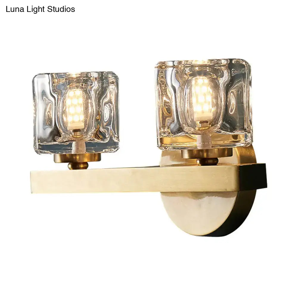 Modern brass wall light with clear crystal block and textured clear glass shades for living room illumination