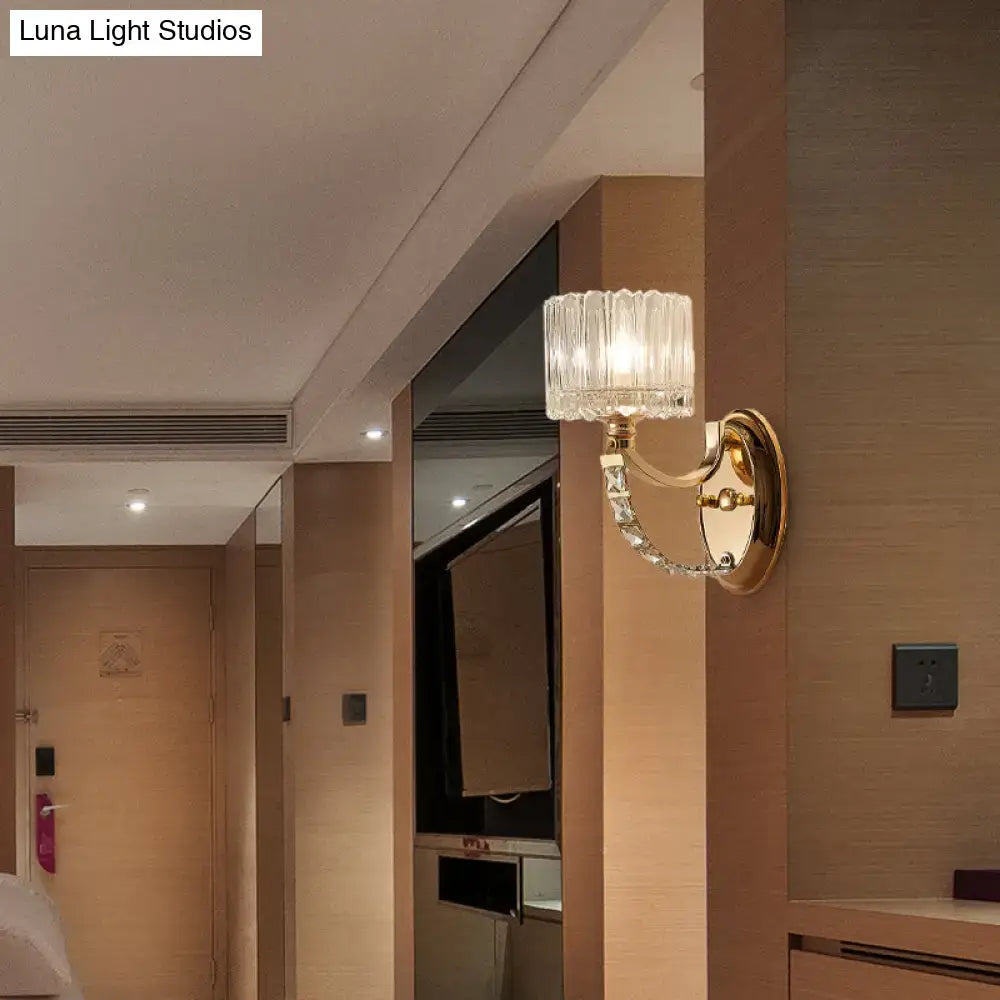 Elegant modern brass wall sconce with a gold-finished metal base and clear glass shade for bedroom lighting