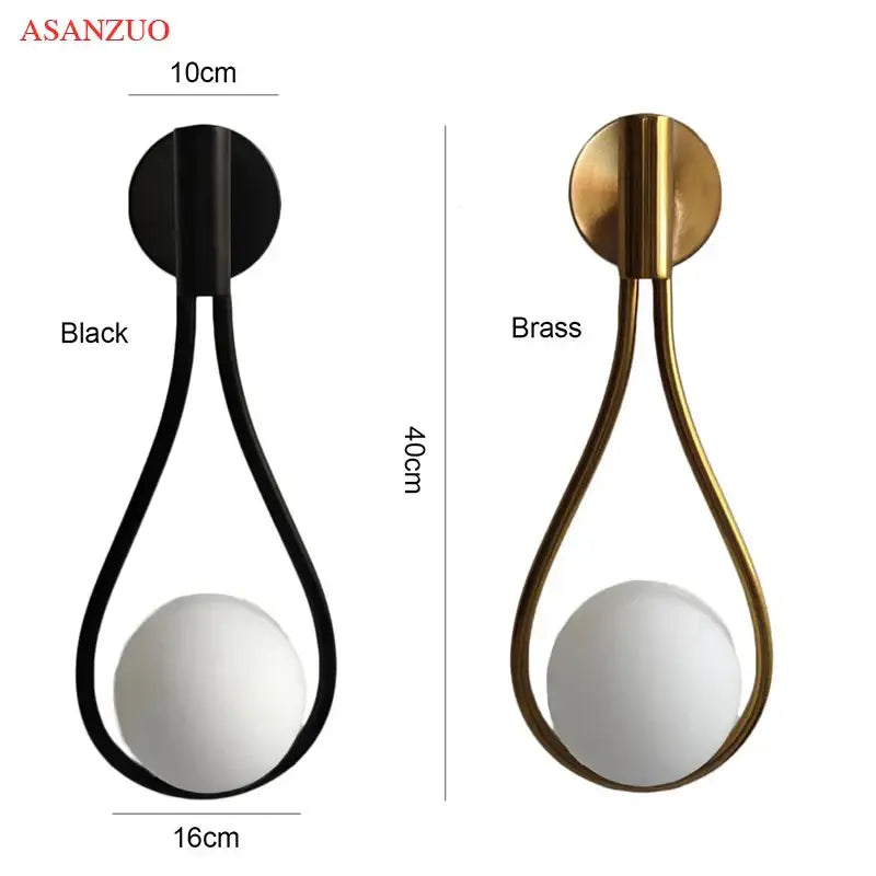 Modern brass wall sconce with frosted glass teardrop shade featuring a sleek brass metallic frame for living room decor