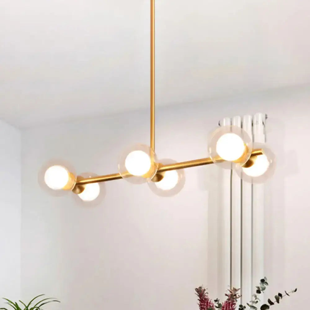 Modern gold-toned bar pendant light with five clear white bubble glass shades for white bubble island lighting