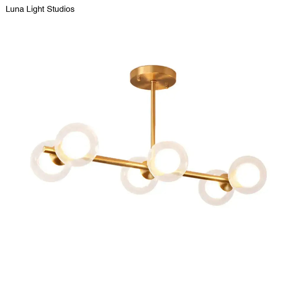 Gold-toned modern chandelier with five frosted glass rings in a clear white bubble island light design by DecorBites