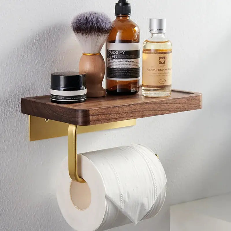 Modern brass and dark wood toilet paper holder with shelf and gold-toned mounting displaying toiletries above paper holder