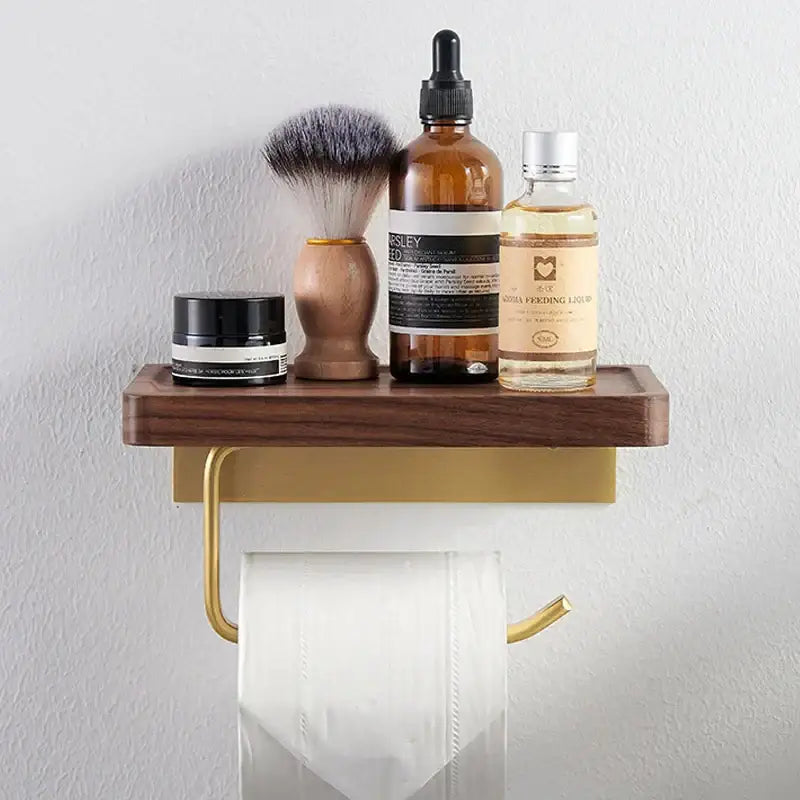 Modern brass and wood toilet paper holder with gold-toned wall-mounted paper holder and dark wood shelf for bathroom use