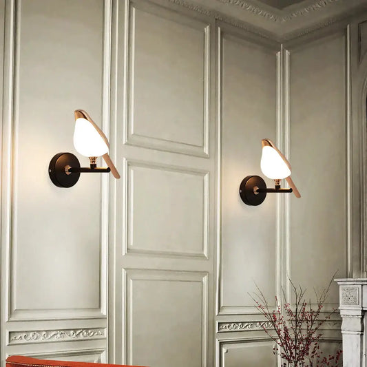 Pair of modern bronze bird wall lights with warm-toned glass shades perfect for living room decorbites bird wall light