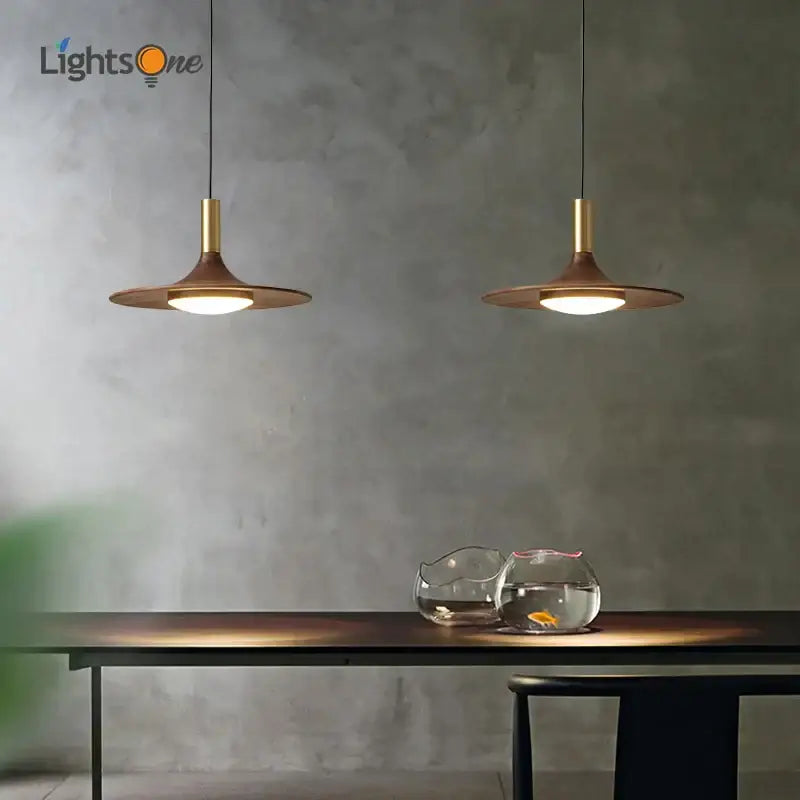 Two bronze-finished black walnut ufo pendant lights from decorbites hang sleekly in a modern dining room setting