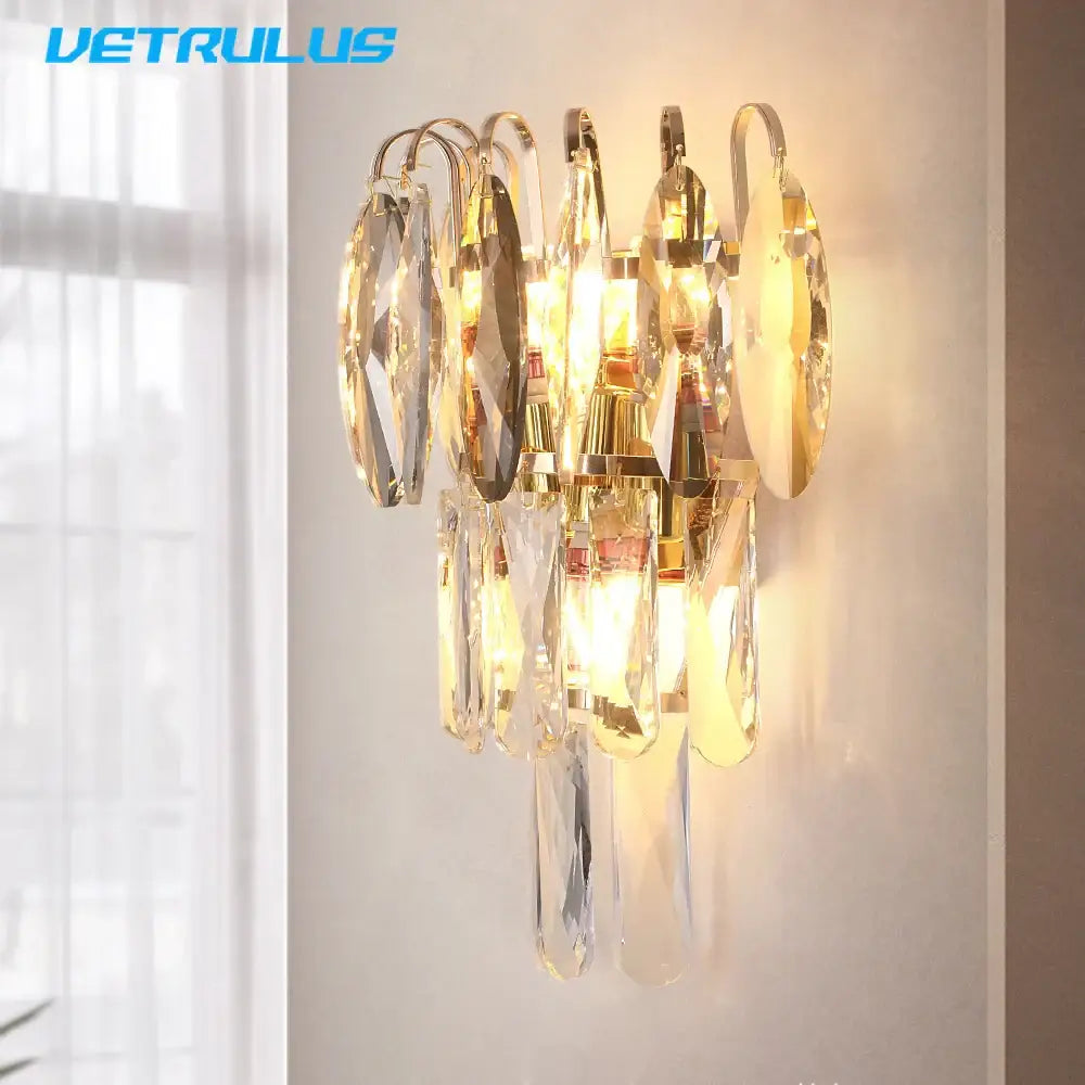 Modern bronze decorbites crystal led wall light featuring a gold-toned wall sconce with cascading crystal droplets and glass accents