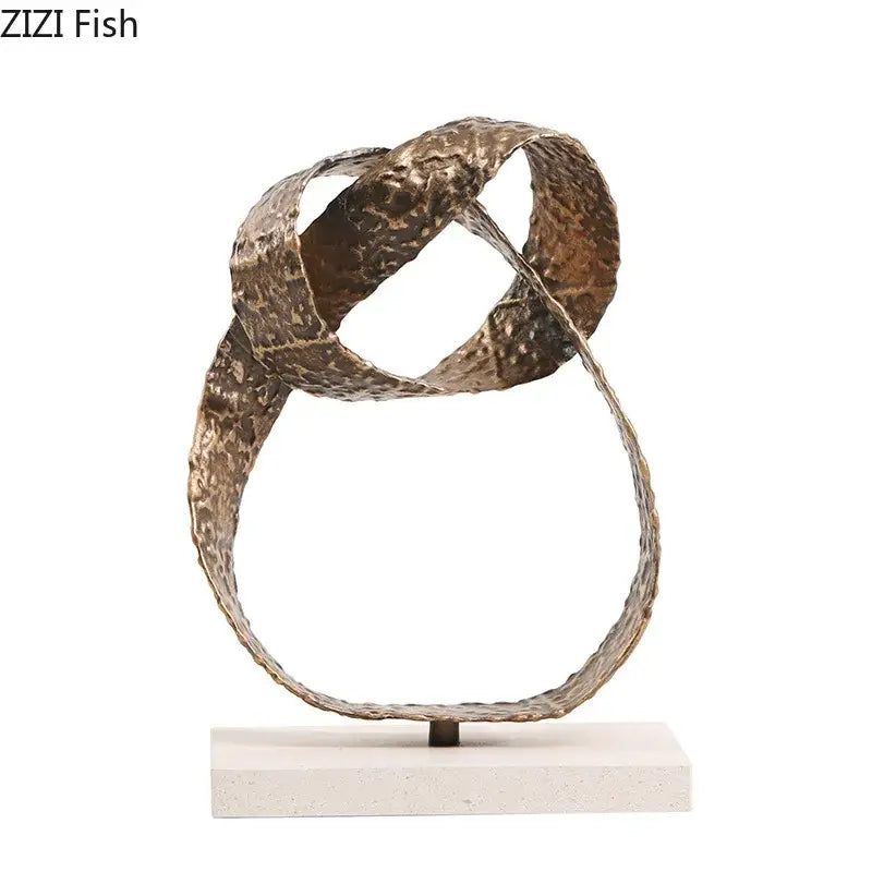 Modern bronze intertwined geometry sculpture with textured bands on a white marble base desk decoration decorbites