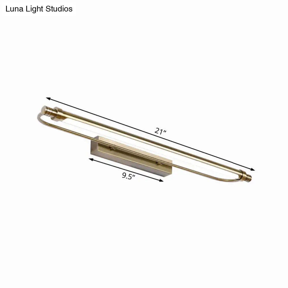 A sleek 21-inch brass tubed vanity light fixture with curved arms providing warm white lighting for bathrooms