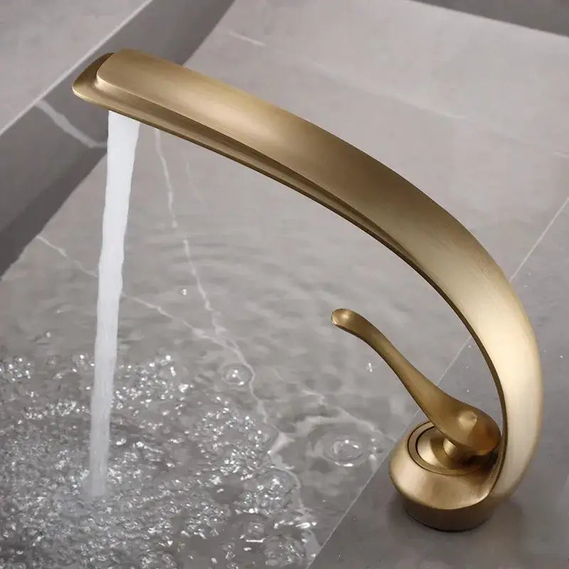 A sleek curved modern decorbites bronze waterfall bathroom faucet in brass with smooth metallic finish for basins