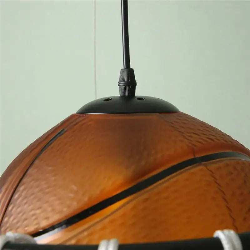 Modern brown basketball pendant lights featuring an orange textured basketball-shaped pendant with black seams decorbites basketball pendant