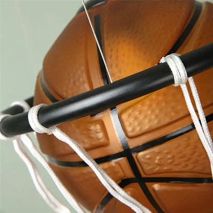Modern brown basketball pendant lights featuring an orange basketball with black lines suspended in a white net decorbites basketball pendant