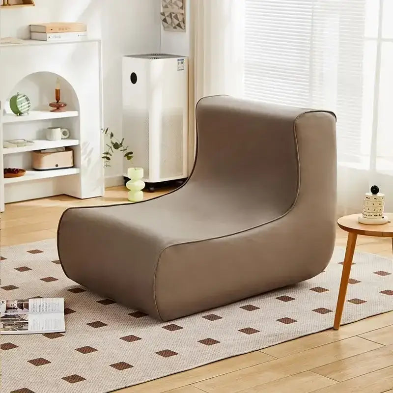 A sleek taupe upholstered lounge chair with minimalist design featured in decorbites internet celebrity lazy sofa collection