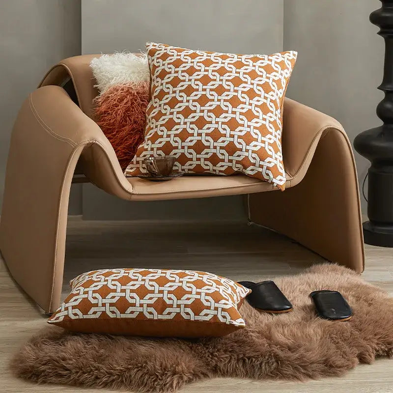 Tan leather armchair with curved modern design and decorbites brown coffee geometric cushion cover for living room