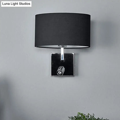 Modern brown fabric and chrome wall light with black cylindrical lampshade and adjustable spotlight for bedroom use