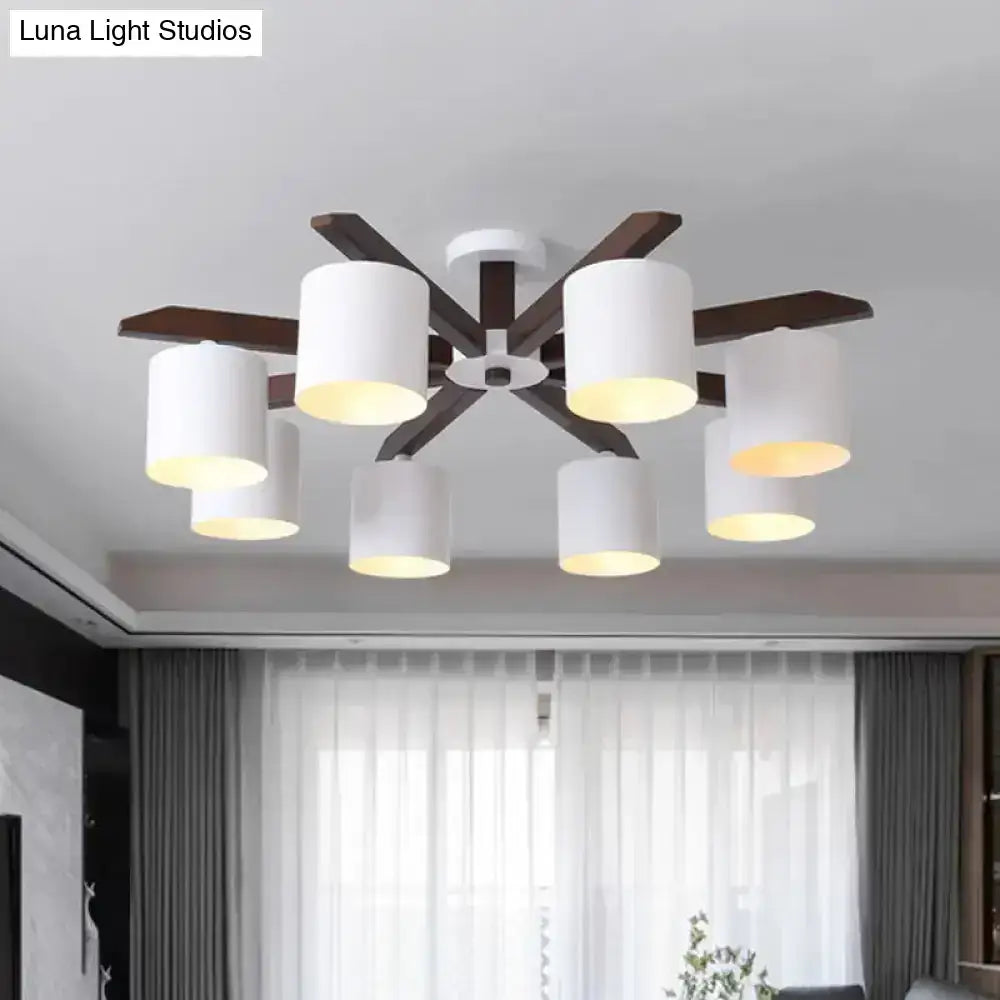 Modern brown and white ceiling mount chandelier with six white cylindrical shades and dark wood arms for living room