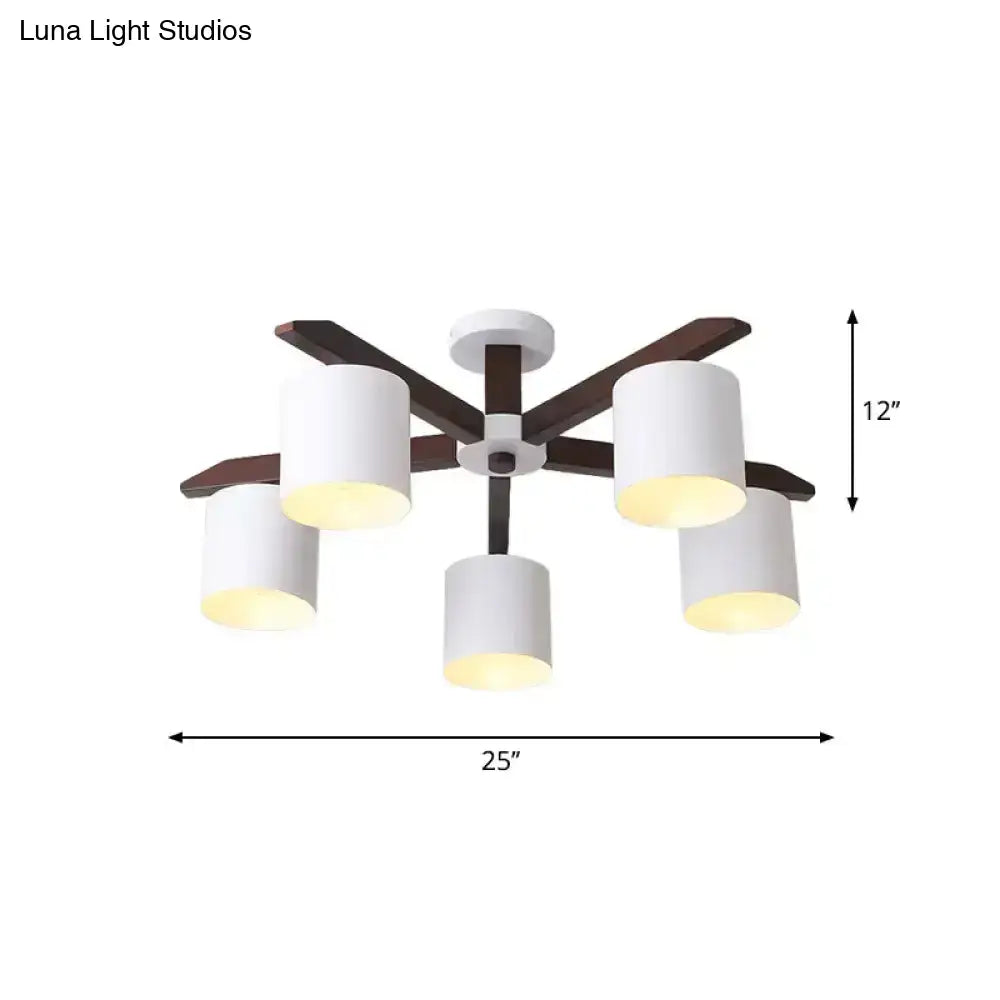 Modern brown and white ceiling mount chandelier with five white cylindrical shades and dark wood arms for living room