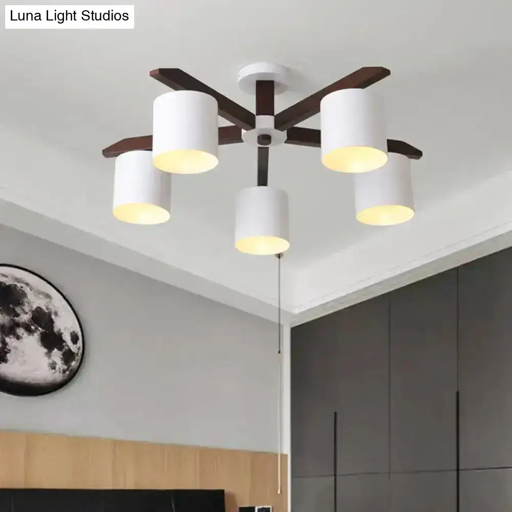 Modern brown and white ceiling mount chandelier with five white cylindrical shades and dark wood arms for living room
