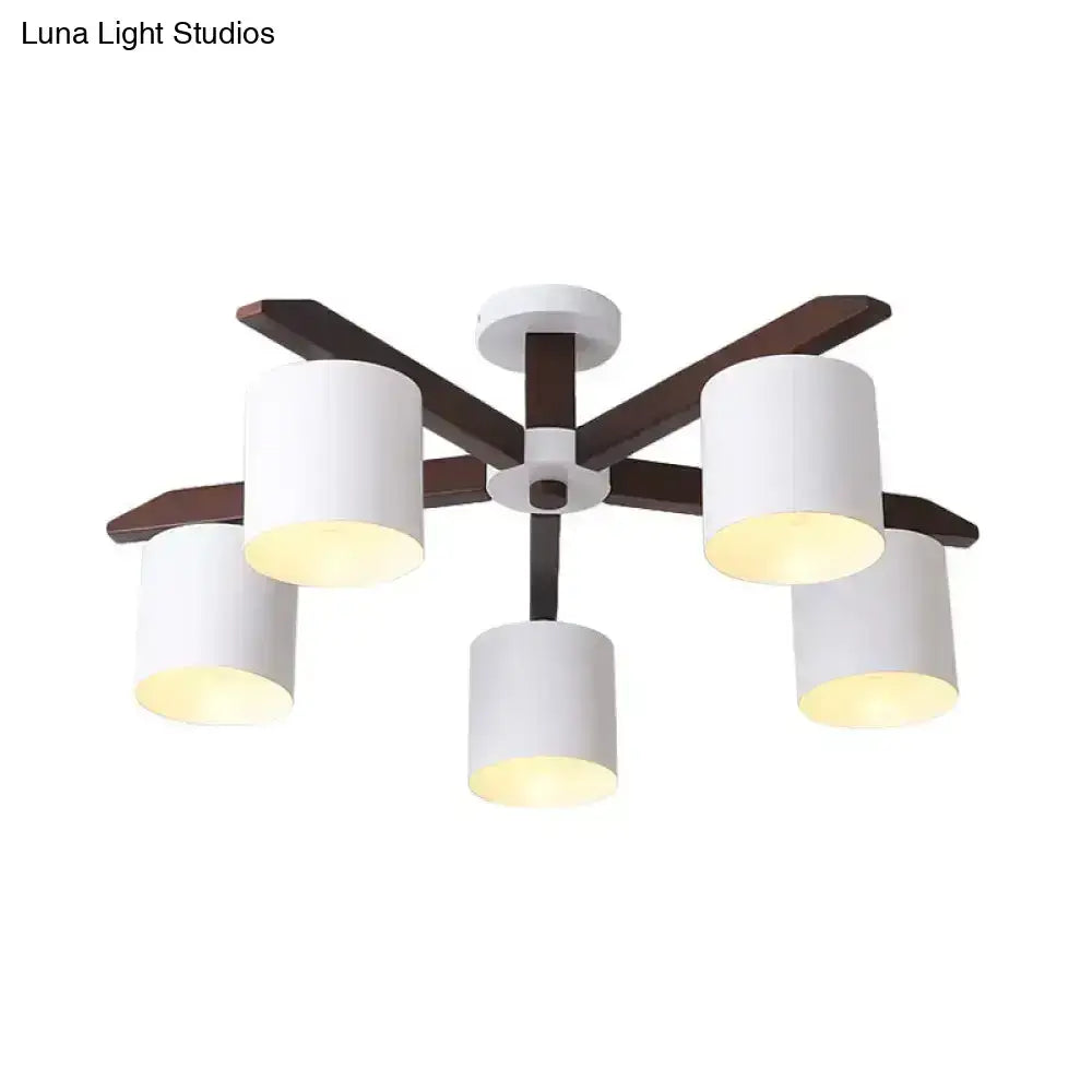 Modern brown and white ceiling mount chandelier with five white cylindrical shades and dark wood arms for living room