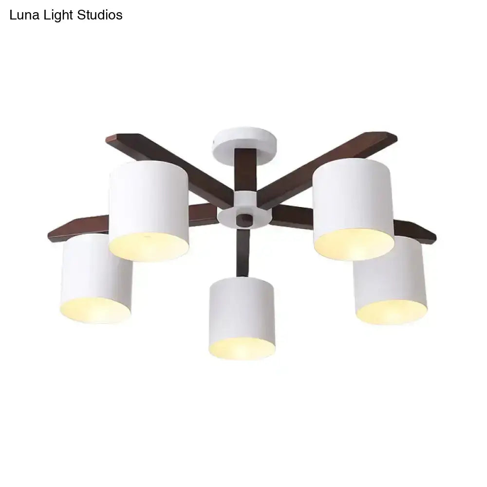 Modern brown and white ceiling mount chandelier with five white cylindrical shades and dark wood arms for living room use