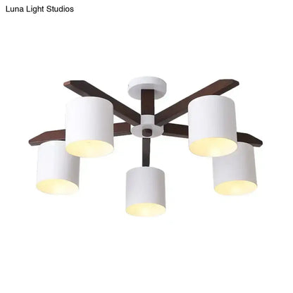 Modern brown and white ceiling mount chandelier with five white cylindrical shades and dark wood arms for living room use