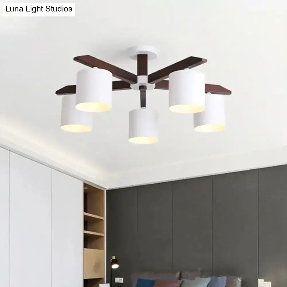 Modern brown and white ceiling mount chandelier with five white cylindrical shades and dark wood arms for living room