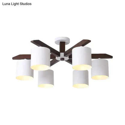Modern brown and white ceiling mount chandelier with six white cylindrical shades and dark wood arms for living room