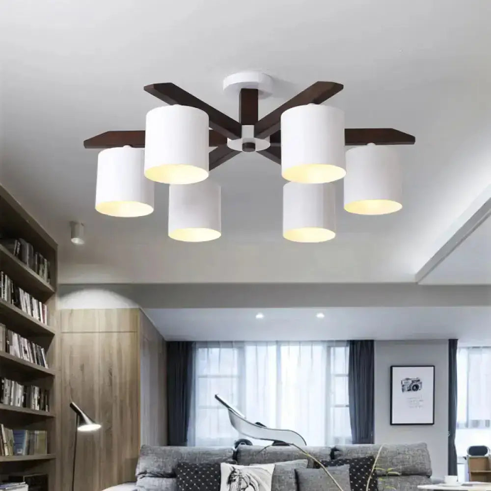 Modern brown and white ceiling mount chandelier with six white cylindrical shades and dark wood arms for living room