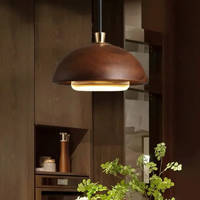 Modern brown wood dome pendant light with warm-toned bronze dome and brass finish for kitchen island lighting