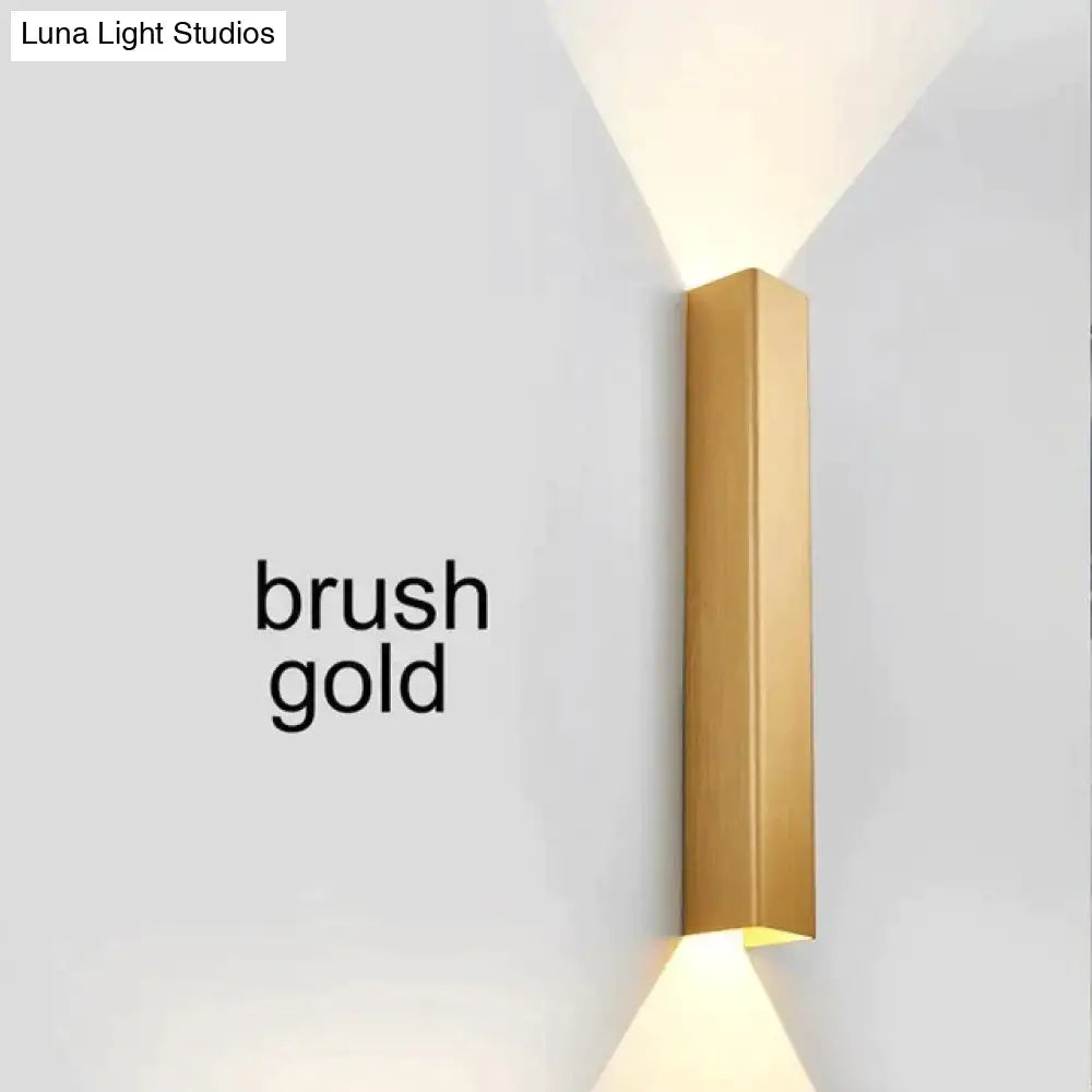 Modern brushed aluminum rectangular wall sconce with a brushed gold finish for ambient bedroom lighting