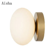Aisha brand wall lamp with a frosted golden glass ball and brushed brass base for modern decorbites golden glass decor