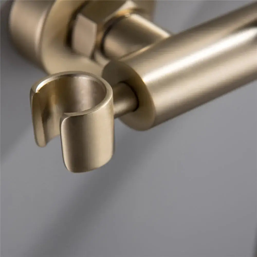 Modern brushed brass hand held bidet sprayer kit with a sleek cylindrical towel rack in a minimalist design