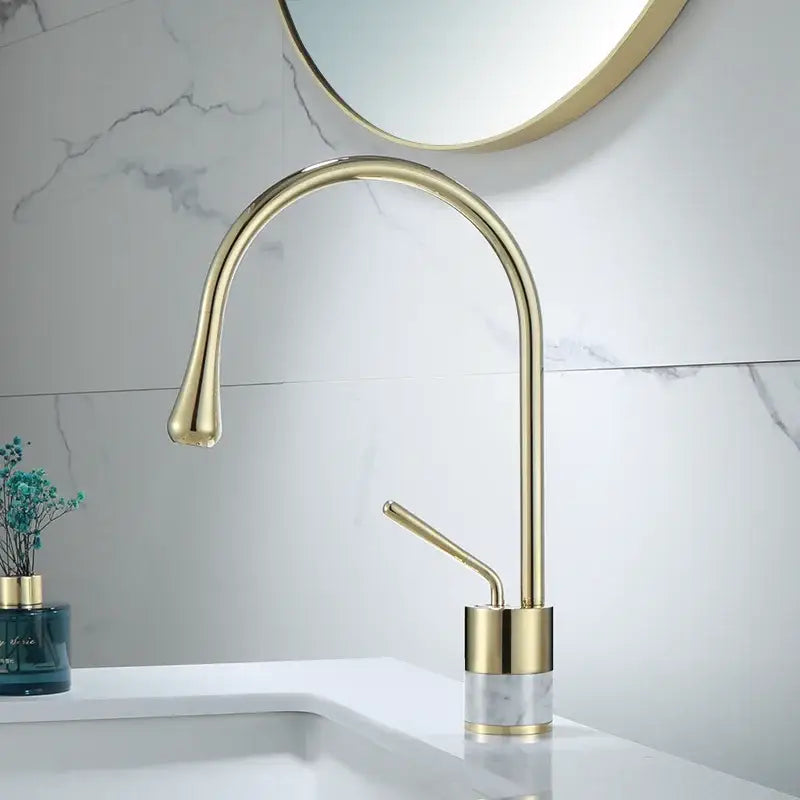Modern brushed gold brass bathroom sink faucet with sleek curved spout and marble base in gold brass finish