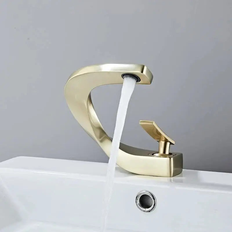 Modern brushed gold basin faucet with sleek curved waterfall design and polished finish by decorbites basin faucet