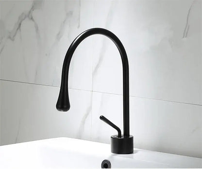 Black matte basin faucet with curved spout and single lever handle complementing decorbites brushed gold style