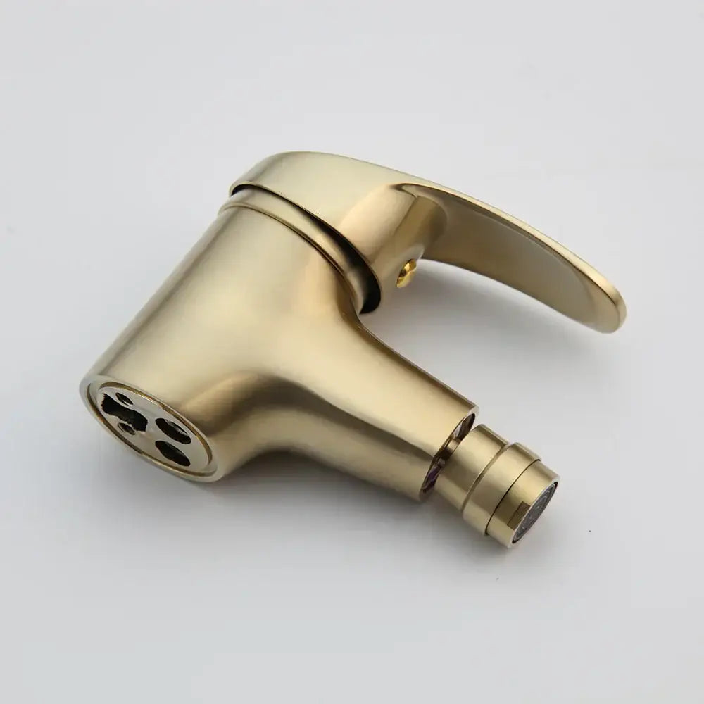 Modern brushed gold basin mixer tap with sleek curved spout and spray head in a brushed metal finish