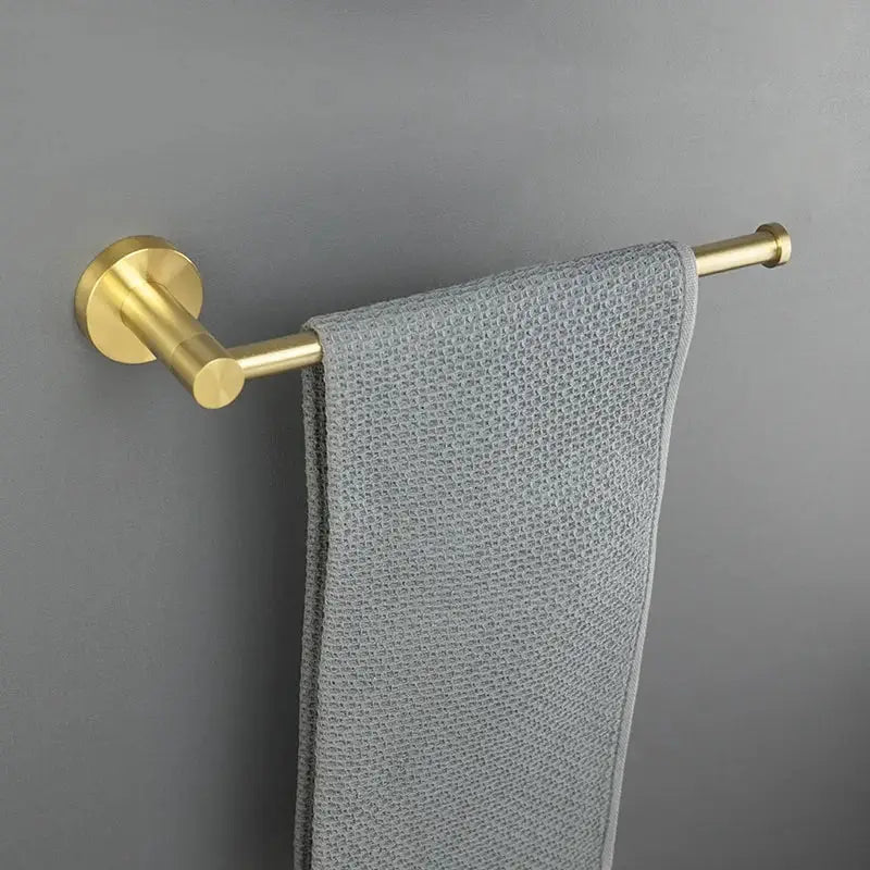 A modern brushed gold bath hardware set towel rack with a gray textured towel for bathroom accessories