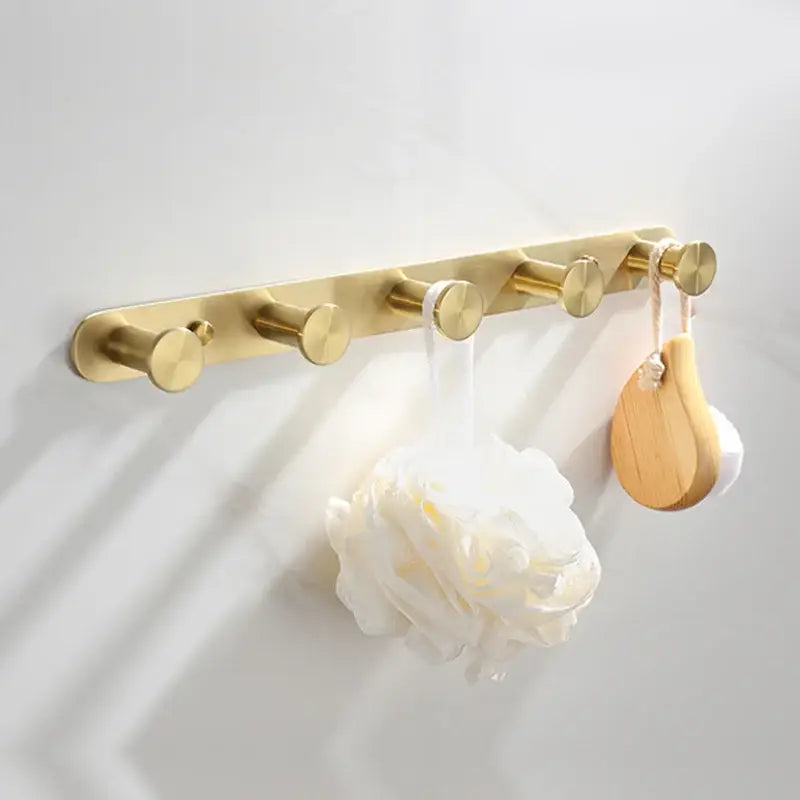 Gold-toned wall-mounted hook rack with five circular brushed gold hooks from decorbites brushed gold bathroom set