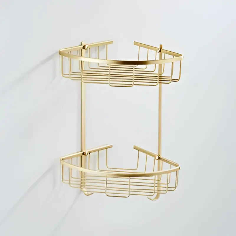 Gold-colored metal two-tier corner shower caddy with wire mesh design in modern brushed gold bathroom hardware set