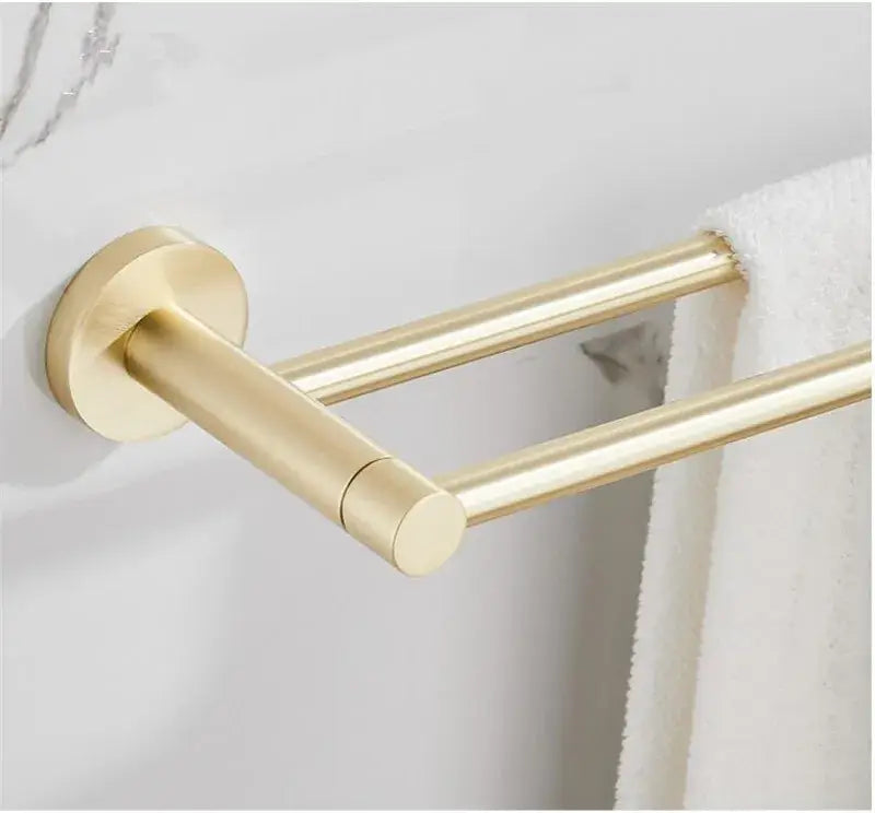 Modern brushed gold bathroom hardware set featuring a gold double towel rack with sleek cylindrical bars and circular base