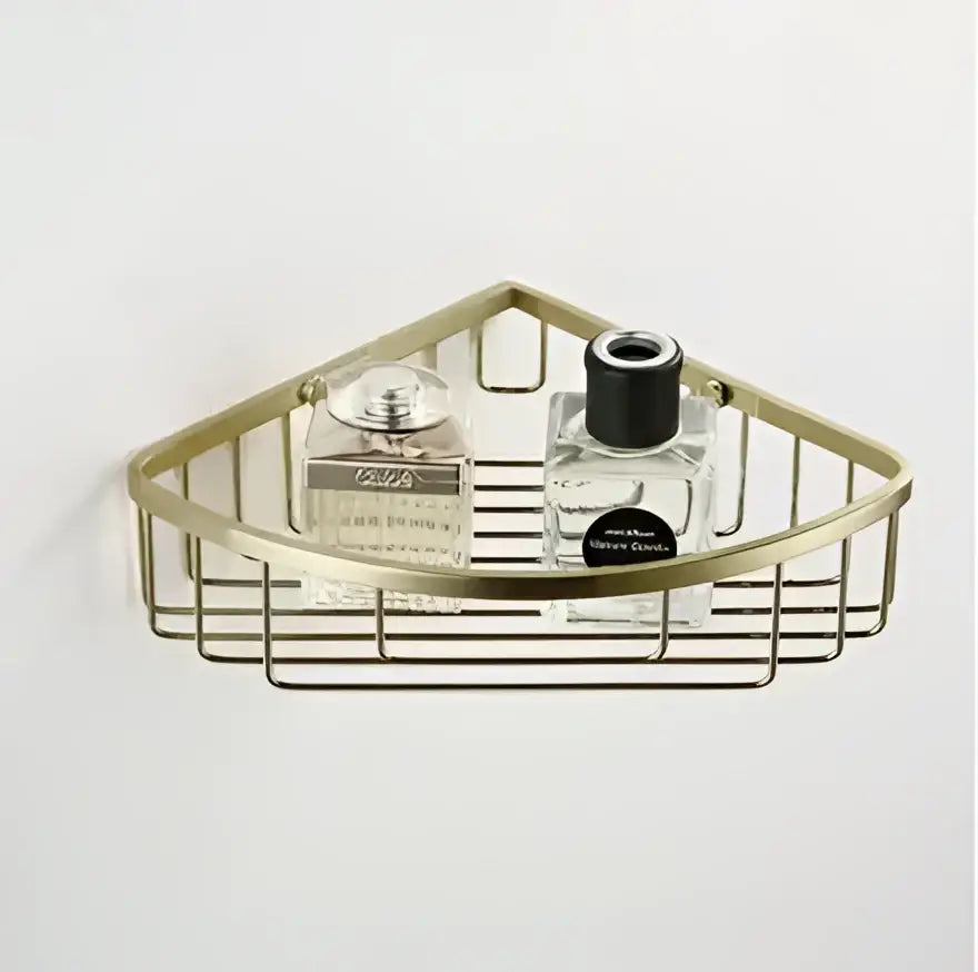 Modern brushed gold hardware set corner shelf with wire mesh design holding two glass perfume bottles decorbites brushed gold