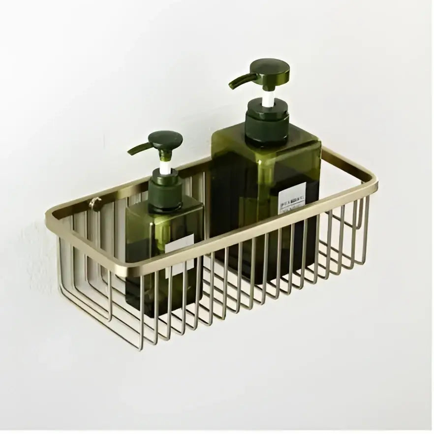 Brass wire mesh wall-mounted shelf with two dark green glass pump bottles in a decorbites brushed gold hardware set