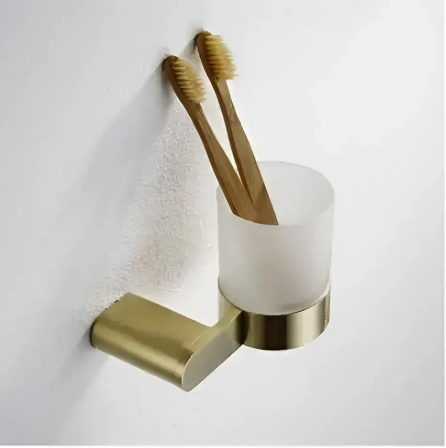 Modern brushed gold wall-mounted hardware set with frosted glass cup holding bamboo toothbrushes by decorbites brushed gold