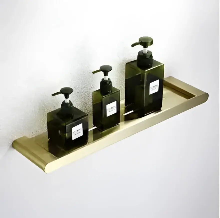 Three dark green soap dispensers with black pumps on a brushed gold tray in a decorbites brushed gold hardware set
