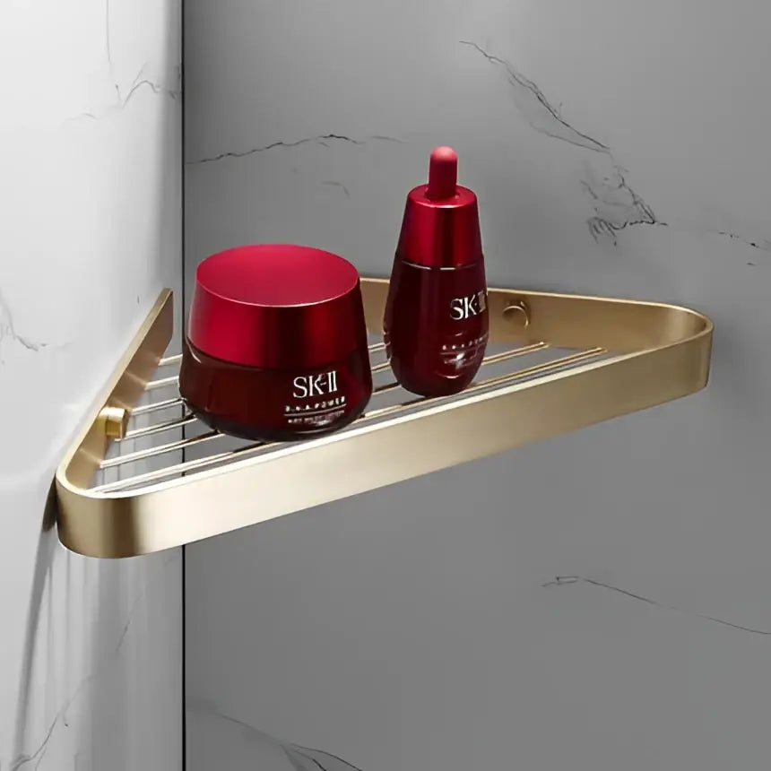 Gold-toned triangular shower caddy from decorbites brushed gold hardware set holding two sk-ii skincare products