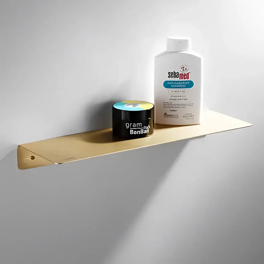 Modern brushed gold bathroom hardware set featuring a gold-toned metal towel rack with sleek minimalist design and angled edge