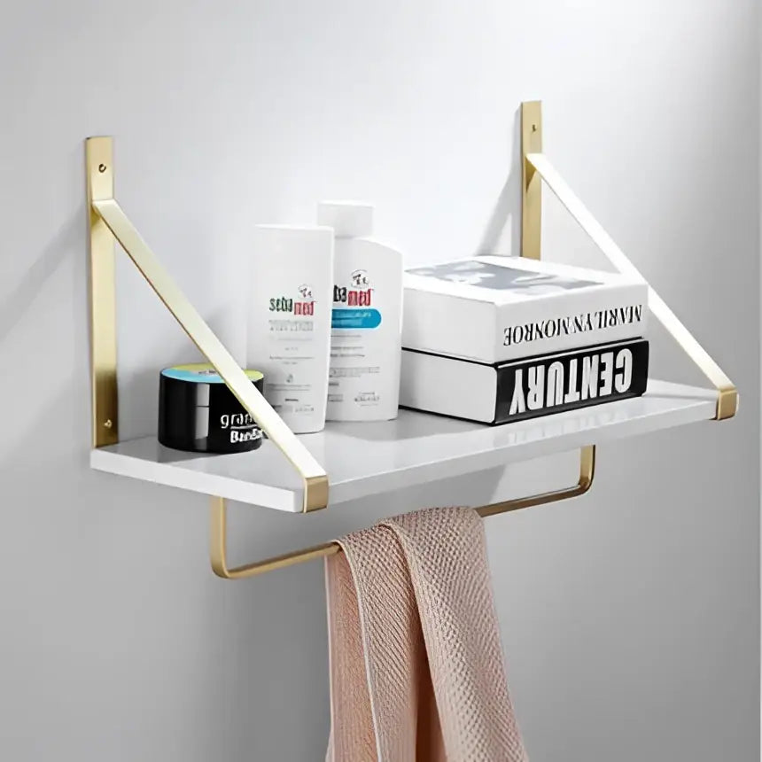 Modern brushed gold bathroom hardware set featuring a gold-toned wall-mounted shelf with white marble surface and brackets