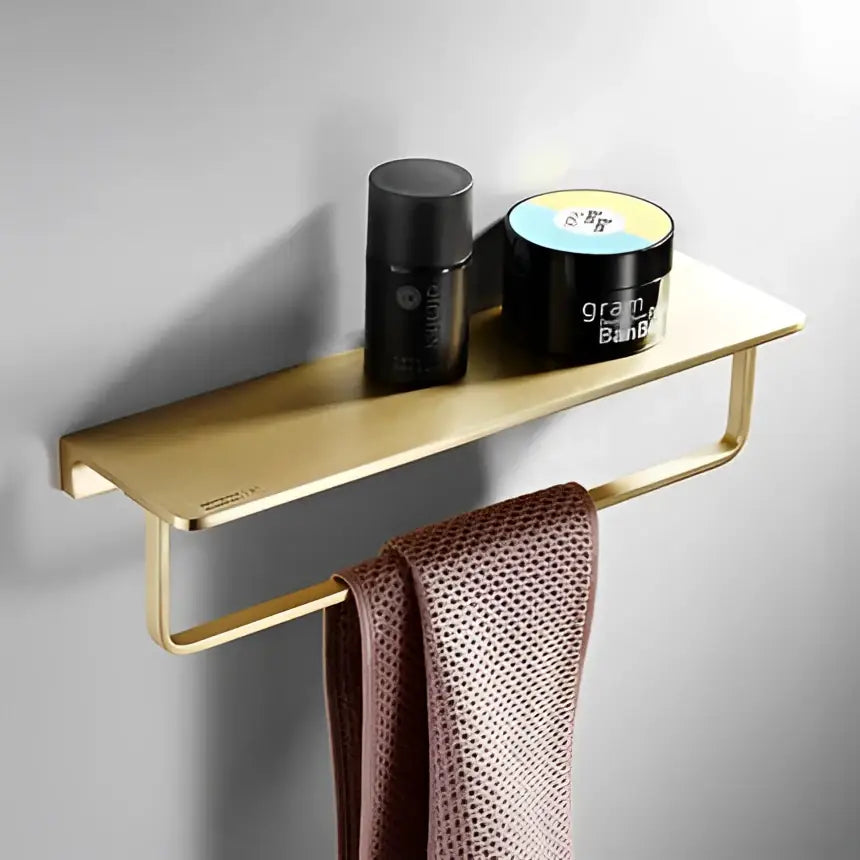 Modern brushed gold hardware set with wall-mounted towel rack featuring a sleek minimalist design and integrated shelf